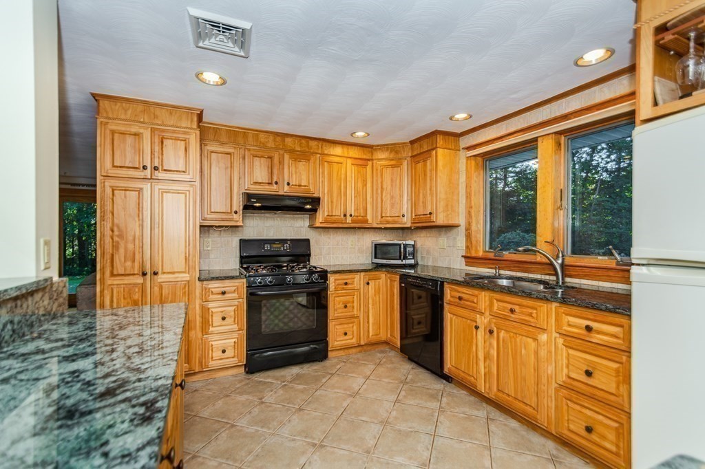 7 Ruthellen Road Chelmsford, MA 01824 - Photo 19 of 40 a kitchen with stainless steel appliances granite countertop a stove top oven a sink and dishwasher