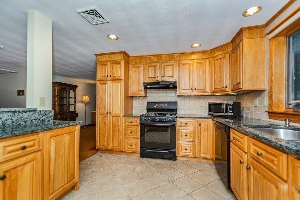 7 Ruthellen Road Chelmsford, MA 01824 - Photo 20 of 40 a kitchen with stainless steel appliances granite countertop a stove a sink and a refrigerator