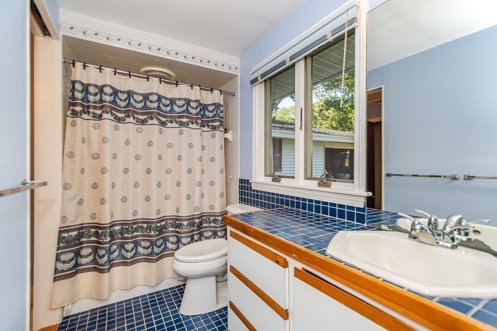 7 Ruthellen Road Chelmsford, MA 01824 - Photo 36 of 40 a bathroom with a sink a toilet a window and shower