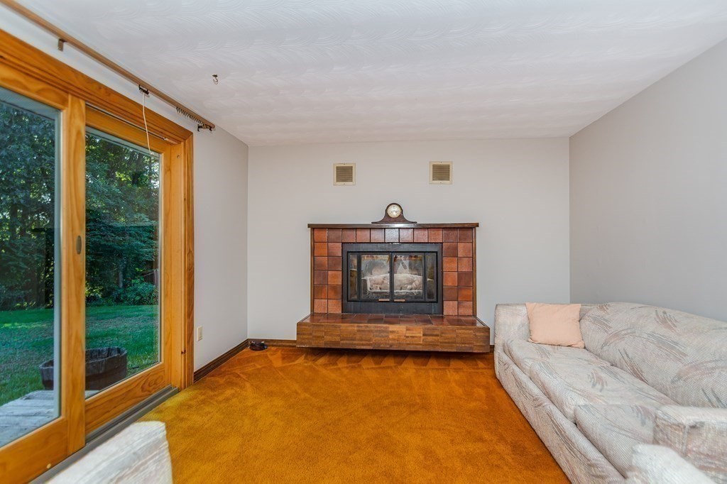 7 Ruthellen Road Chelmsford, MA 01824 - Photo 10 of 40 a living room with furniture a rug and a fireplace