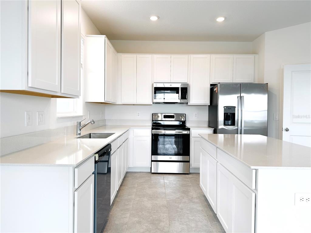700 Daring Drive Davenport, FL 33837 - Photo 6 of 22 a kitchen with stainless steel appliances granite countertop a sink stove and refrigerator