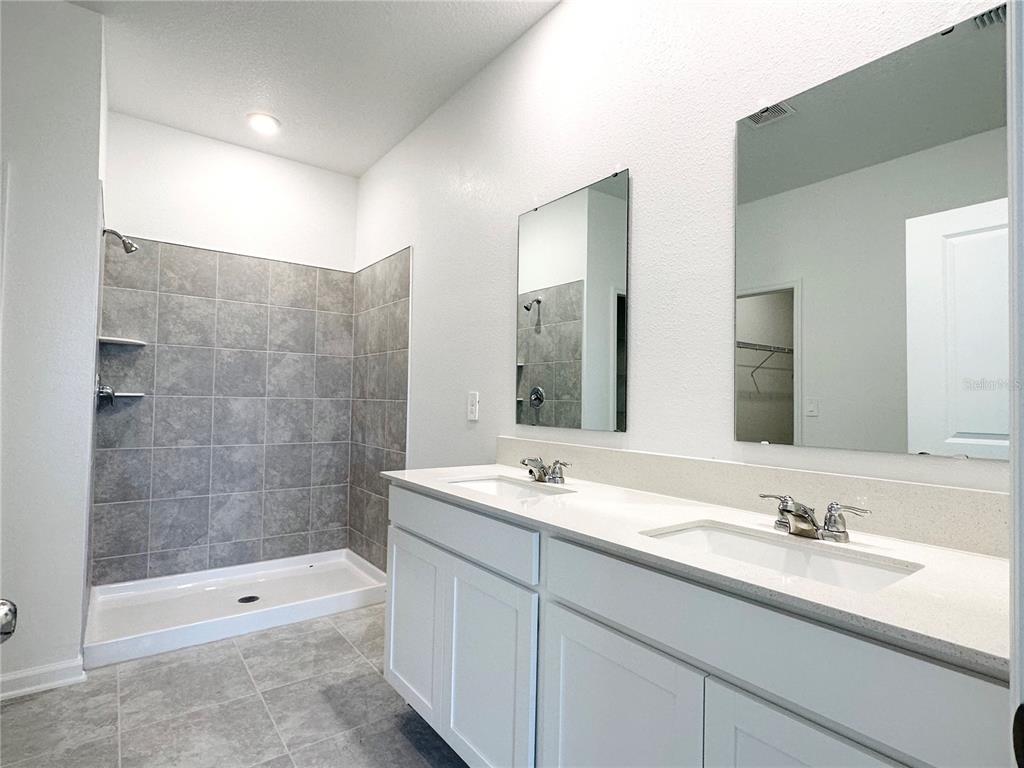 700 Daring Drive Davenport, FL 33837 - Photo 9 of 22 a bathroom with a shower sink vanity granite and a mirror