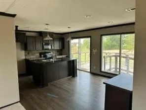 a kitchen with granite countertop a stove a sink and a refrigerator