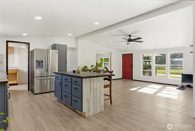 a kitchen with stainless steel appliances granite countertop a refrigerator and a stove top oven