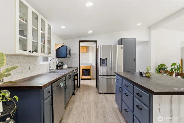 a kitchen with stainless steel appliances a sink stove and refrigerator