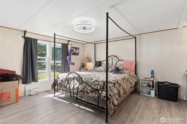 a bedroom with a bed and a large window