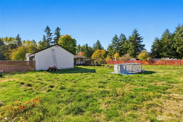 a backyard of a house with plants and a tree