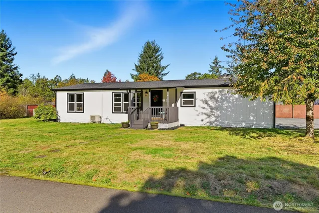 a front view of house with yard and trees in the background