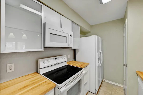 a kitchen with white cabinets and white appliances