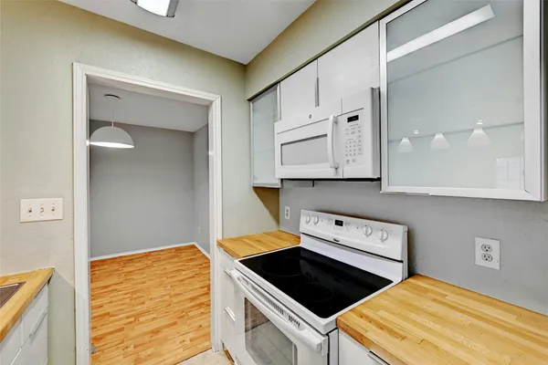 a kitchen with white cabinets and black appliances