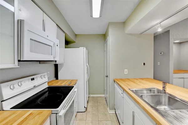 a kitchen that has a sink a stove and a refrigerator
