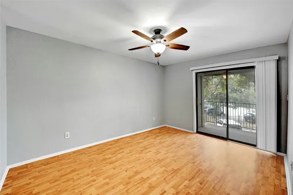 a view of an empty room with chandelier fan