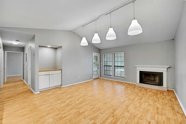 a view of empty room with wooden floor and fireplace