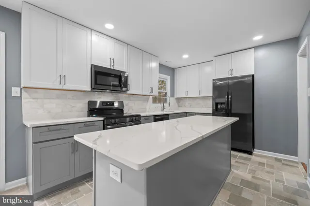 a kitchen with a sink a stove a refrigerator a center island and cabinets