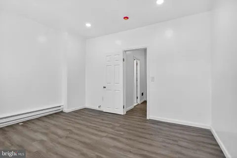 a view of a room with wooden floor and entryway