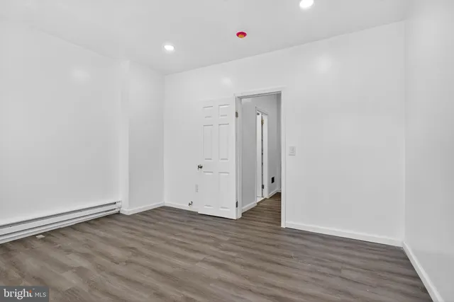 a view of a room with wooden floor and entryway