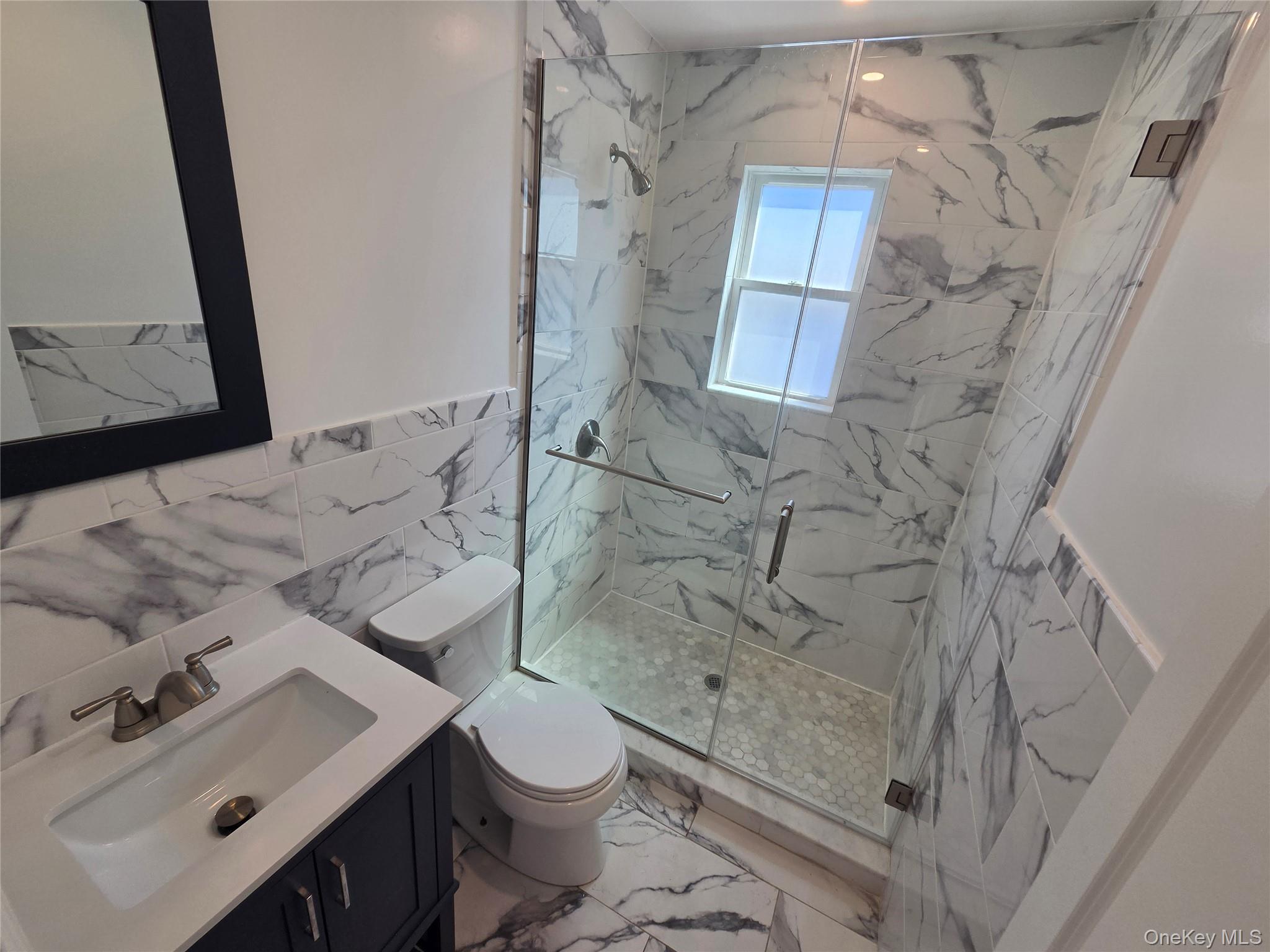 965 Main Street, Unit 2 New Rochelle, NY 10801 - Photo 7 of 12 Contemporary bathroom featuring a glass-enclosed shower with honeycomb tile flooring