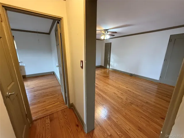 a view of a hallway with wooden floor