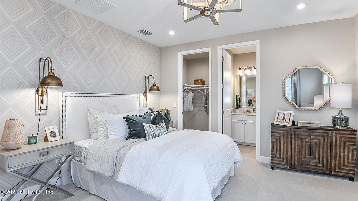 518 Marquesa Circle St. Johns, FL 32259 - Photo 19 of 27 a bedroom with a bed a mirror on dresser and a chandelier