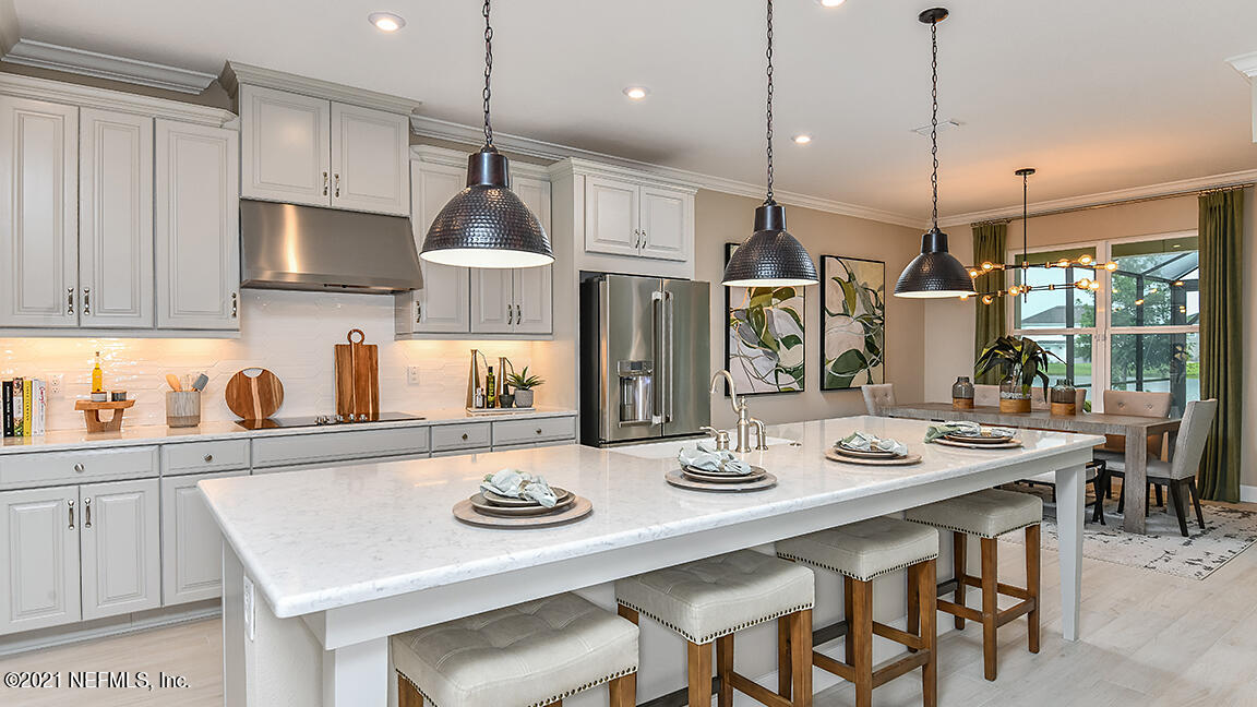 518 Marquesa Circle St. Johns, FL 32259 - Photo 9 of 27 a kitchen with stainless steel appliances granite countertop a sink a stove a dining table and chairs