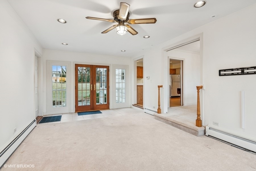 725 Milton Road Inverness, IL 60067 - Photo 7 of 24 an empty room with chandelier fan and windows