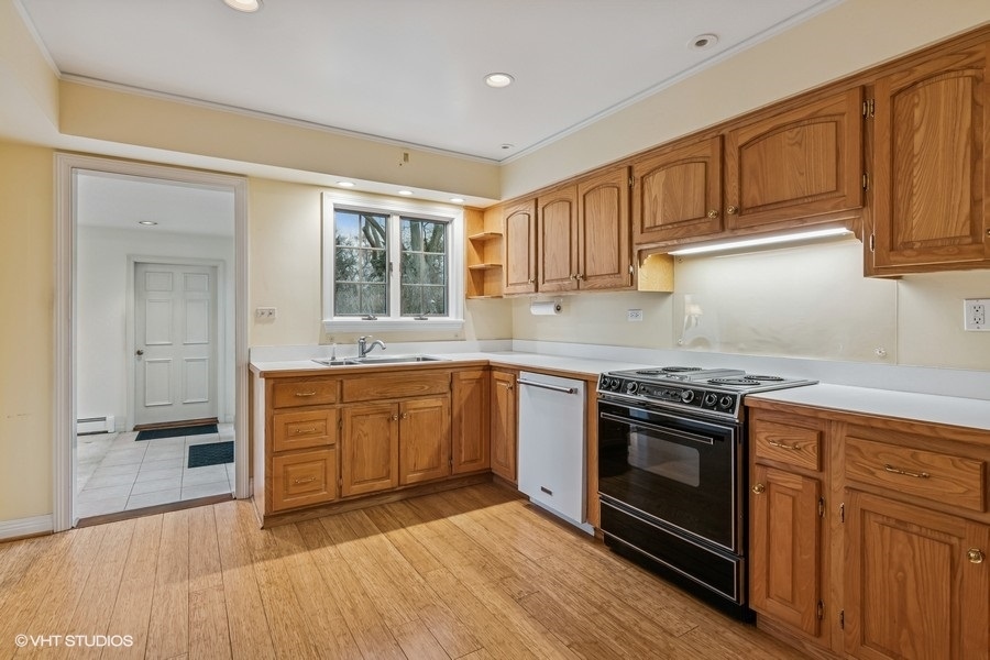 725 Milton Road Inverness, IL 60067 - Photo 8 of 24 a kitchen with stainless steel appliances granite countertop a stove a sink and a refrigerator