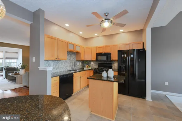 a kitchen with stainless steel appliances granite countertop a refrigerator a stove and a sink