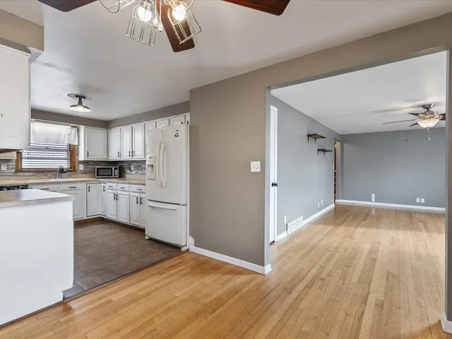 a kitchen with a refrigerator and white cabinets