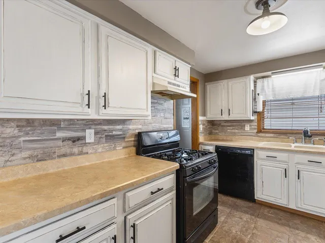 a kitchen with stainless steel appliances granite countertop a sink stove and cabinets