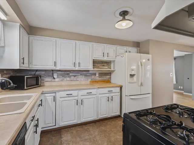 a kitchen with white cabinets and appliances
