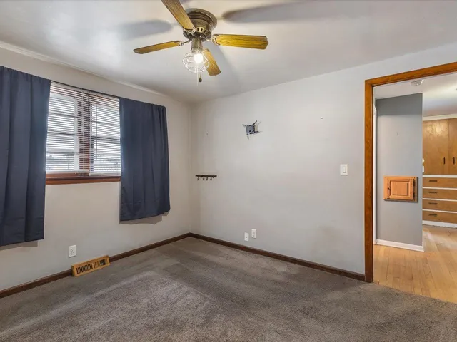 an empty room with windows and fan