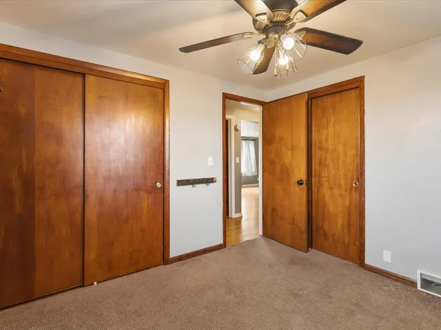 a view of an empty room and a ceiling fan window