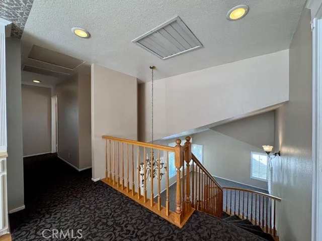 a hallway with white cabinets and wooden floor