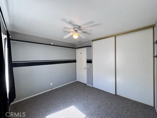 an empty room with a window and a fan