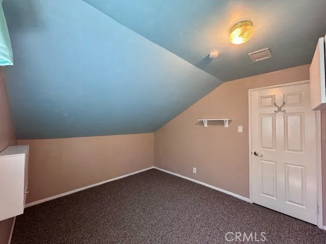 an empty room with wooden floor chandelier fan and windows