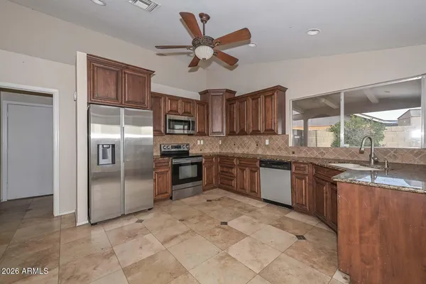 a kitchen with granite countertop wooden cabinets and stainless steel appliances