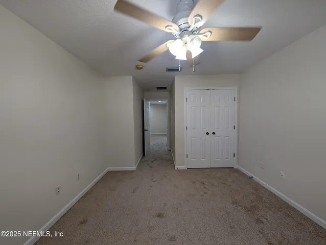 an empty room with a chandelier fan