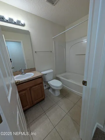a bathroom with a granite countertop sink a toilet and a mirror