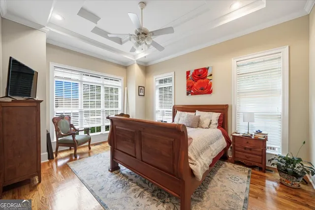 a spacious bedroom with a bed a couch and large window