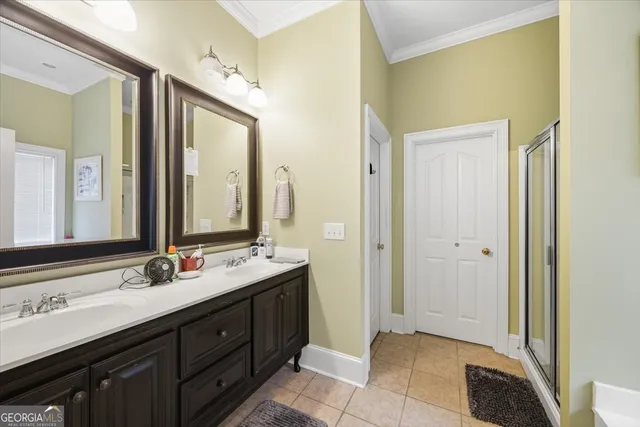 a spacious bathroom with a double vanity sink a large mirror and a shower