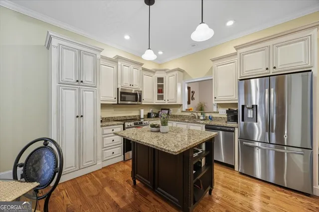 a kitchen with stainless steel appliances granite countertop a refrigerator a stove a sink and a refrigerator