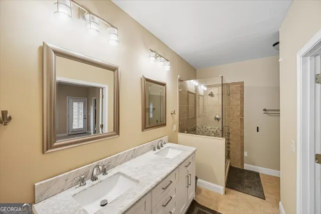 a bathroom with a sink double vanity granite tub shower and a mirror