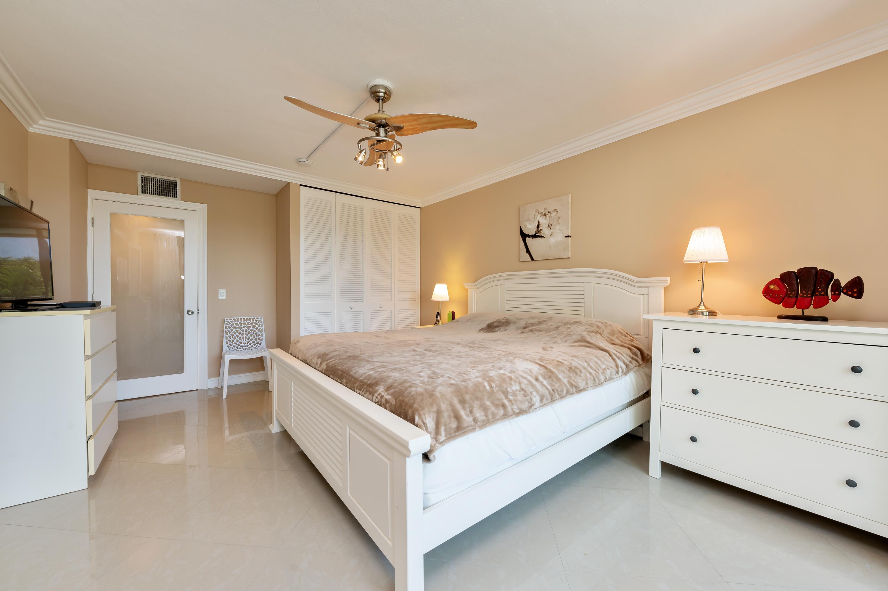 1112 Ocean Terrace, Unit 1B Delray Beach, FL 33483 - Photo 7 of 18 a bedroom with a bed and a chandelier