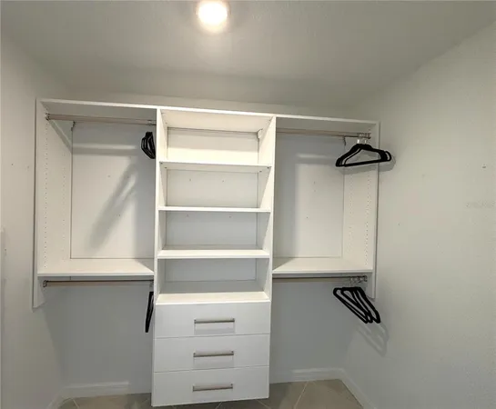 a view of walk in closet with empty racks
