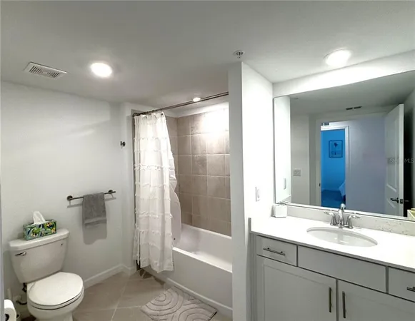 a bathroom with a granite countertop sink toilet a large mirror a shower and a bathtub