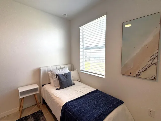 a bed sitting in a bedroom next to a window