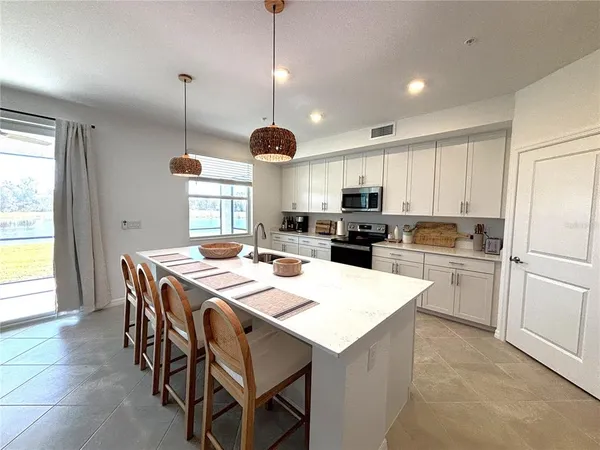 a kitchen with a dining table chairs refrigerator and cabinets