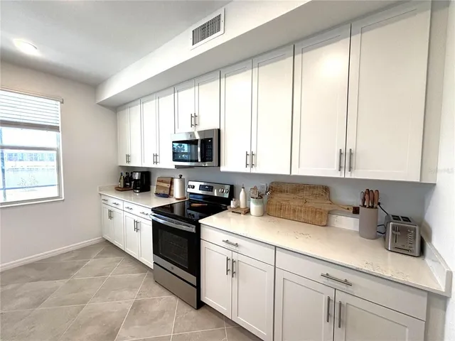 a kitchen with cabinets appliances a sink and a window