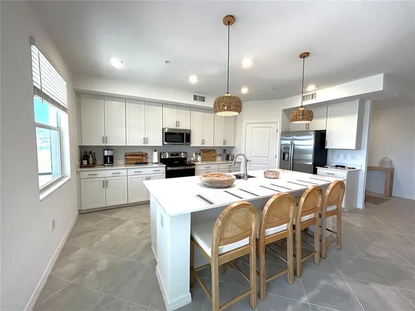 a kitchen with kitchen island granite countertop wooden cabinets and white appliances