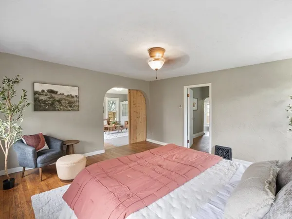 a bedroom with a bed and wooden floor